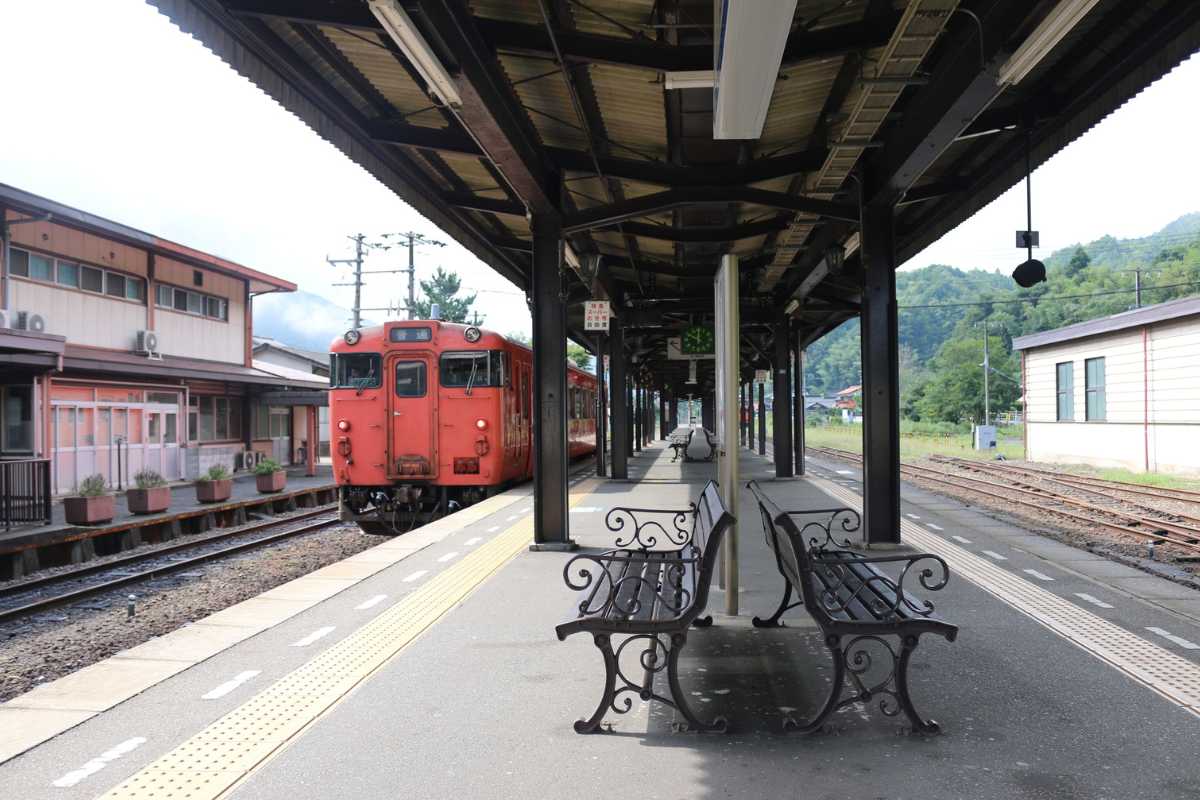 Stazione ferroviaria di Foggia, viaggiatori con bagagli in attesa, tabellone orari, atmosfera di viaggio mattutina, dettagli riconoscibili della stazione