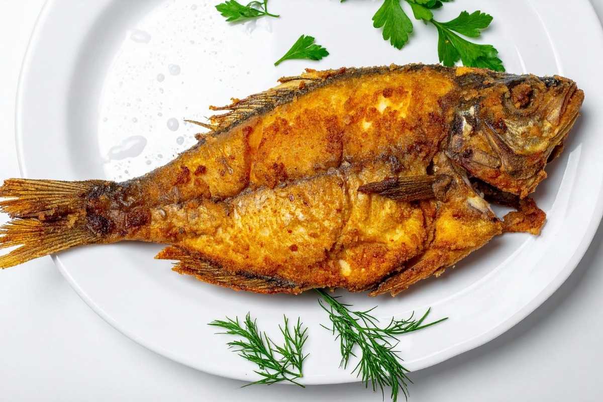Tavolata all’aperto in una trattoria tipica di Vieste con piatti di pesce, pane e vino locale, scorcio del centro storico sullo sfondo